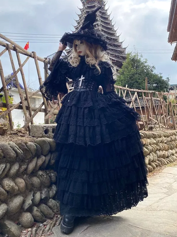Black Gothic witch lolita dress front full-body outdoor view with tiered tulle skirt cross corset and wide brim witch hat