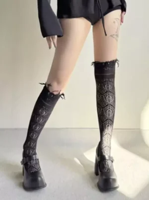 Black vintage hollow lace lolita kneesocks with ruffled cuff and paisley pattern worn with black platform mary janes front view