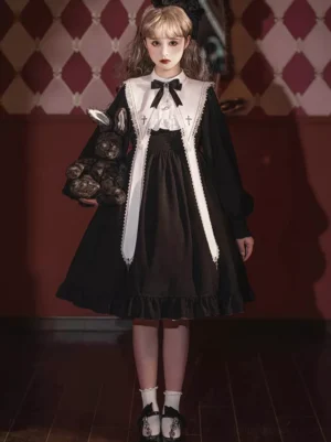 Black and ivory gothic lolita dress full-body front view showing two-tone ruffled hem, long lantern sleeves, bow neckline, and cross embroidery detail against vintage studio backdrop
