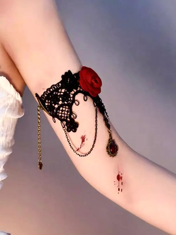 Black floral lace arm cuff with cascading red rose and multi-strand gem chains, close-up detail shot on arm with gothic aesthetic styling