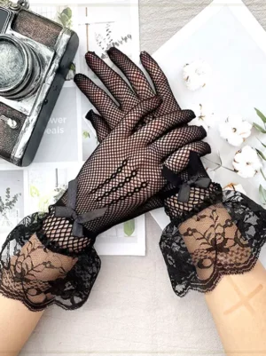 Black lace fishnet gloves with ruffled lace cuffs and small black bow accents displayed in overhead flat lay with vintage camera and floral props for gothic lolita fashion styling