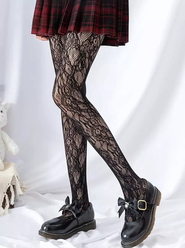 Black embroidered vine lace fishnet stockings side profile leg shot featuring intricate botanical pattern with red tartan skirt
