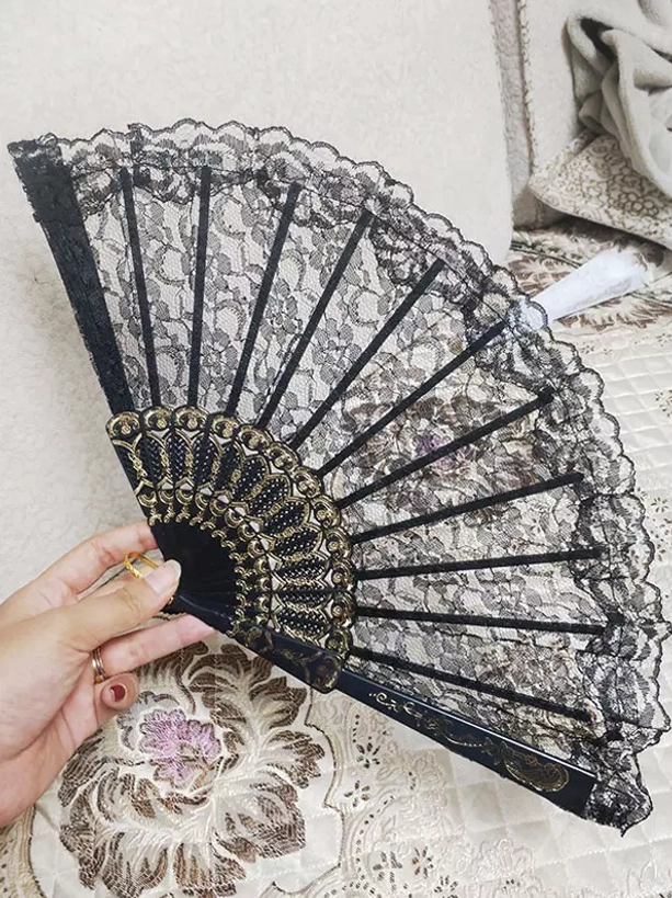 Black lace folding hand fan with gold carved frame held by model hand wearing ring authentic lolita accessory styling coordinate demonstration