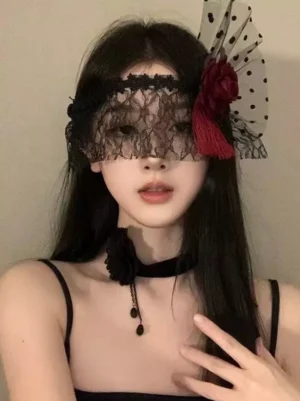 Black lace gothic masquerade eye mask with wine red velvet rose and red tassel worn by model showcasing elegant design details