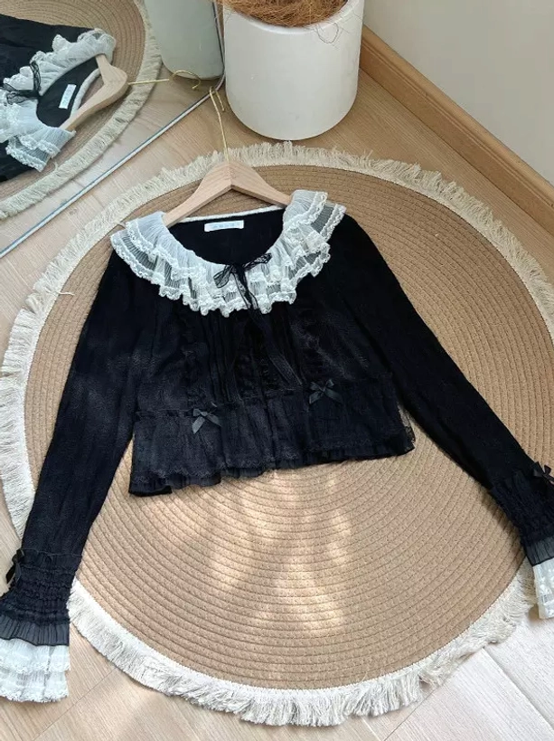 Black lolita cropped cardigan with white lace collar tiny front bows ruffled cuffs overhead flat lay showing elegant contrast details