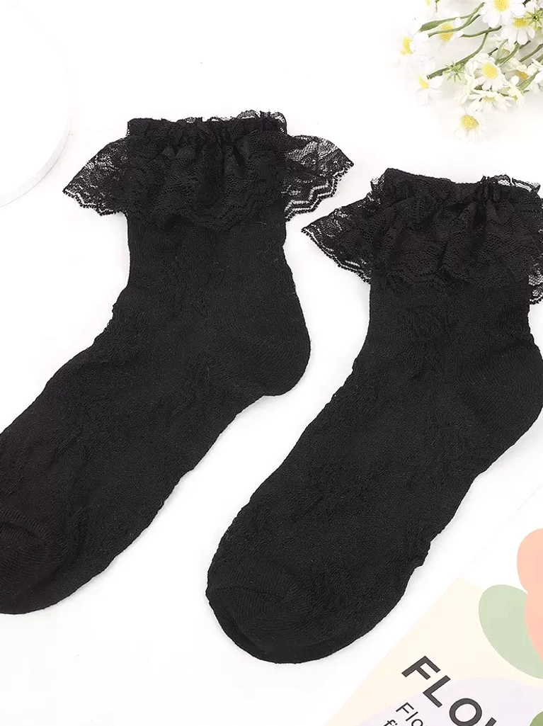 Black lace ankle socks with ruffled cuff detail on light background decorated with small floral accents, gothic lolita aesthetic option
