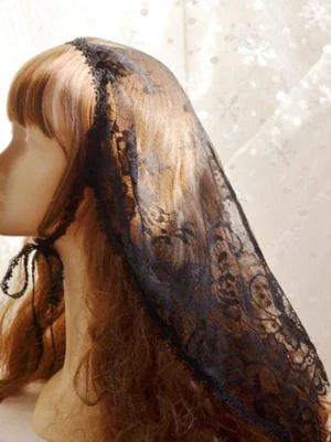 Black lace steampunk lolita headdress veil shown from left side view on mannequin with brown curly hair, featuring tie-fastened straps and delicate floral lace texture