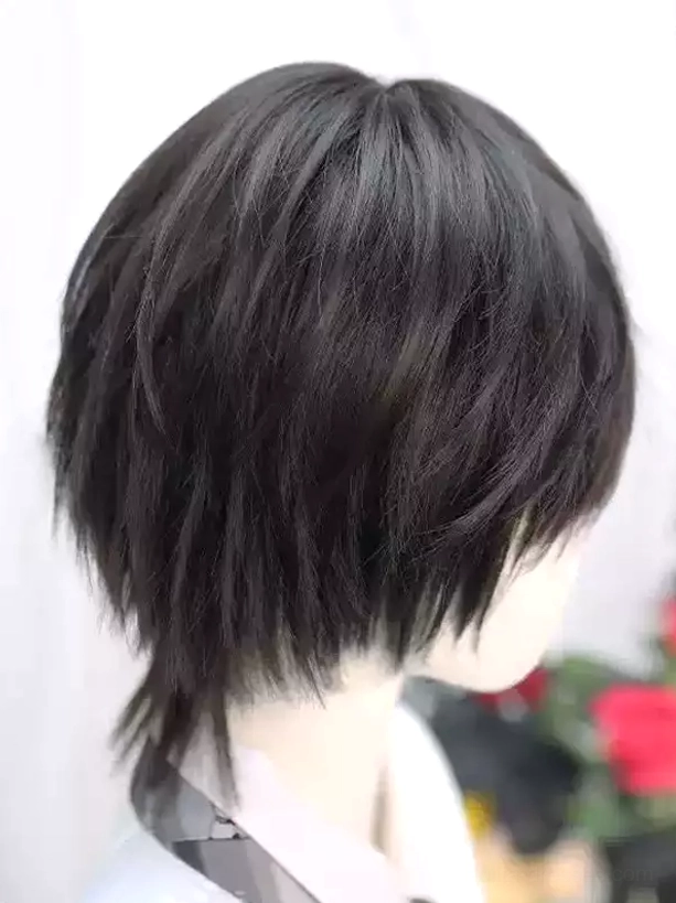 Black layered short lolita wig with tousled ends and side bangs, worn on mannequin with white shirt and black necktie, rear right angle view showing dimensional texture and flipped layered hair construction