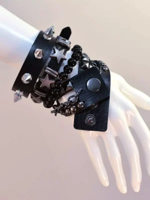 Black layered punk leather spike bracelet close-up on mannequin hand showing silver star studs and beaded chain details from left-top angle