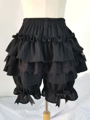 Black Lolita bloomers with layered ruffles and lace trim worn on dress form, featuring satin bow cuffs and elastic waistband, front eye-level view