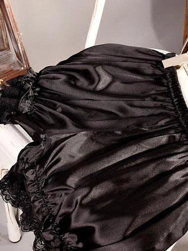 Black lolita bloomers overhead view displaying shiny silk-like fabric, black lace trim details, and full gathered silhouette for classic and gothic lolita aesthetics