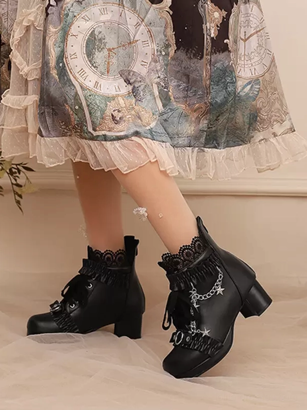 Black Lolita ankle boots front low-angle close-up on model in vintage print Lolita skirt, featuring lace collars, star chain, lace-up design