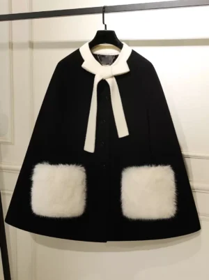 Black sweet lolita winter cape coat with white fuzzy bow collar and square pockets front view on display rack