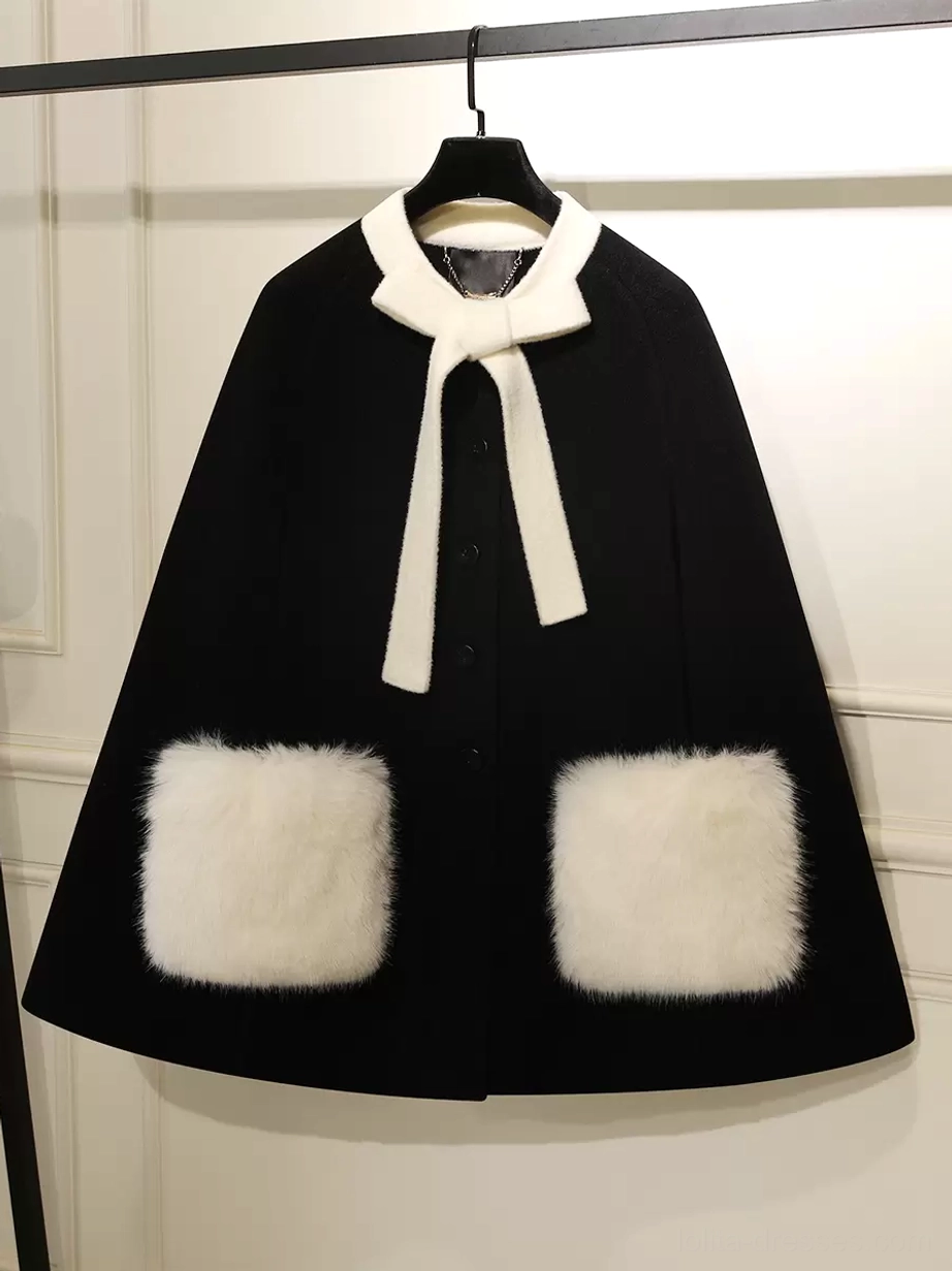 Black sweet lolita winter cape coat with white fuzzy bow collar and square pockets front view on display rack
