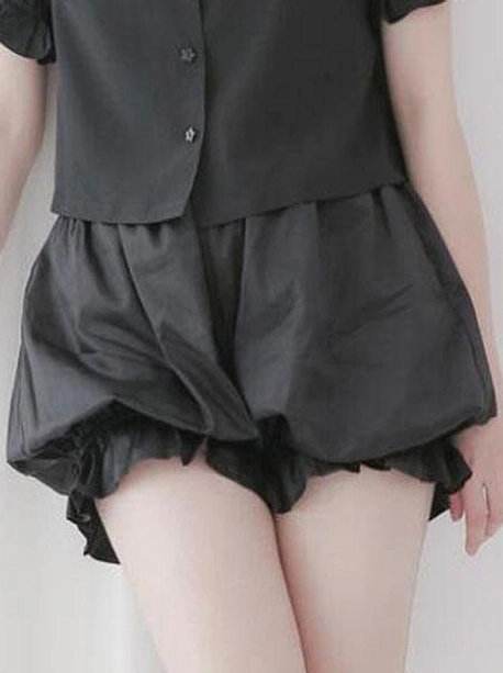 Black lolita cotton bloomer shorts with ruffled elastic leg cuffs and gathered waist, styled with black cropped button shirt, front view displaying puffy balloon silhouette and hem ruffles
