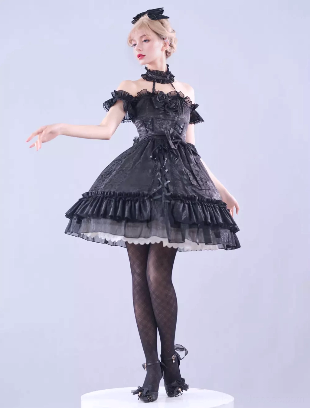 Close-up detail of black lolita dress jacquard fabric texture and layered ruffled skirt hem construction quality