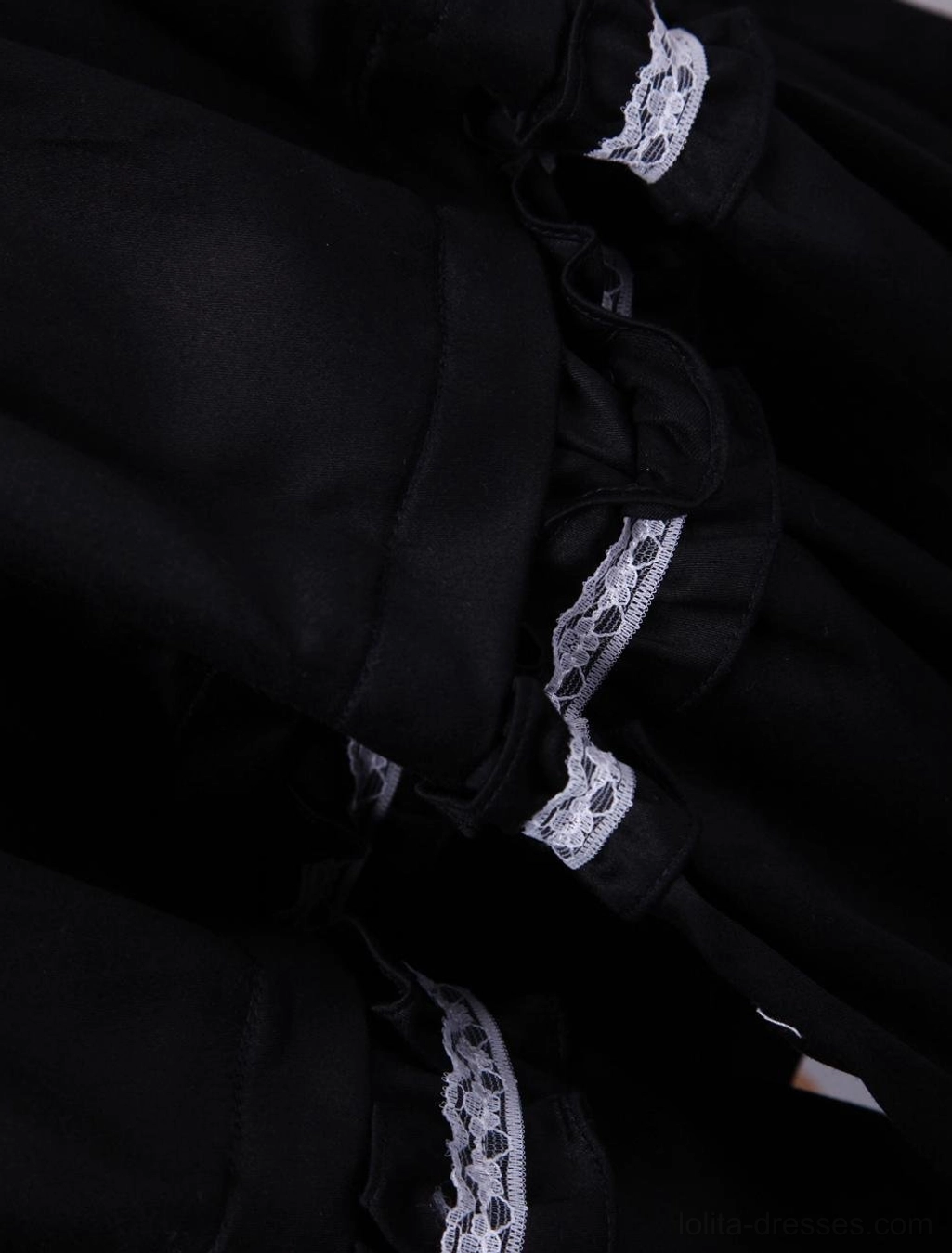 Close-up detail of black classic lolita dress short puffed sleeves with white lace trim edge and gathered shoulder construction