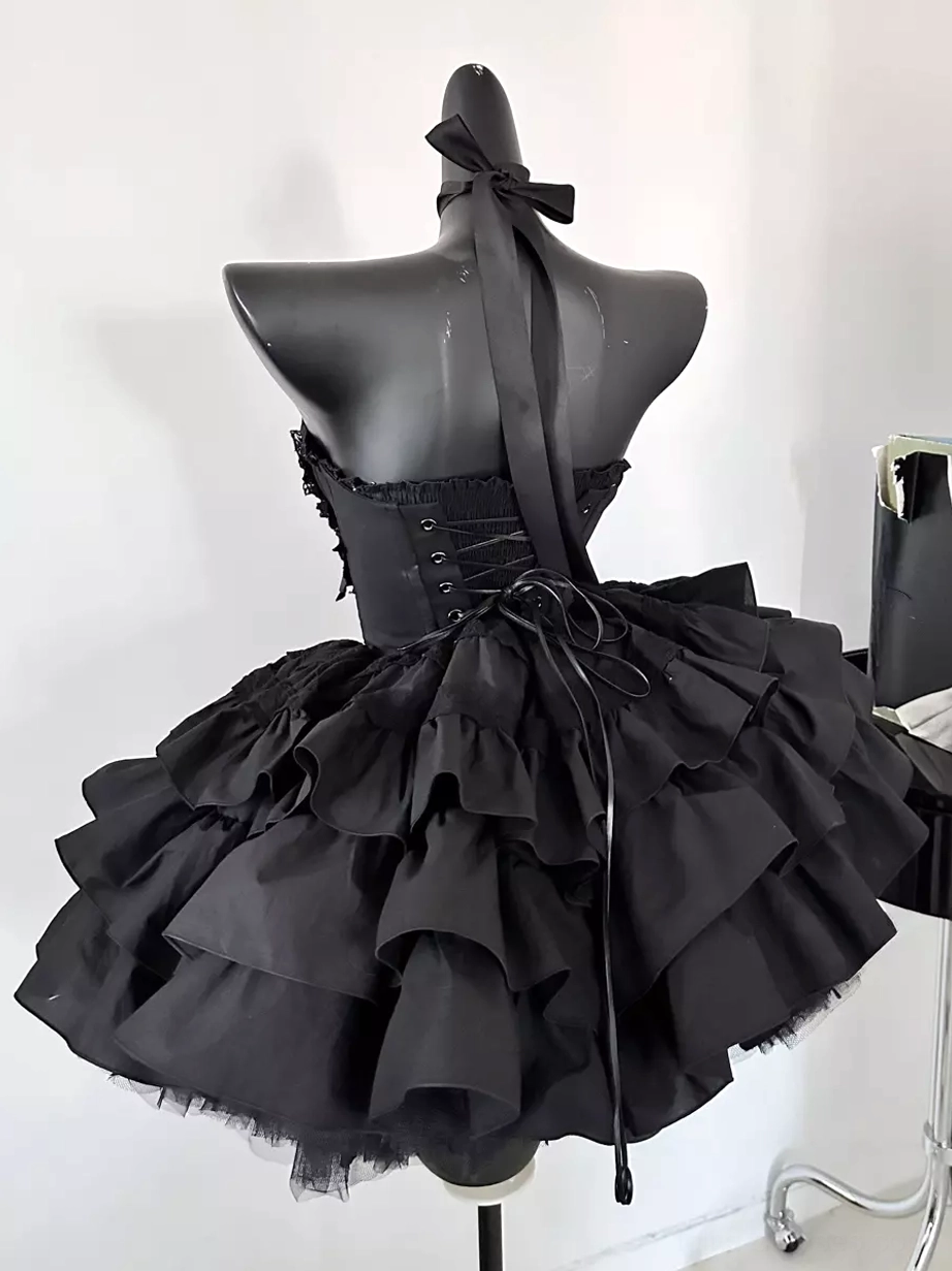 Black Gothic Lolita dress rear view on mannequin featuring lace-up back closure, long halter strap, tulle-trimmed multi-layer ruffle skirt, and authentic lolita construction details