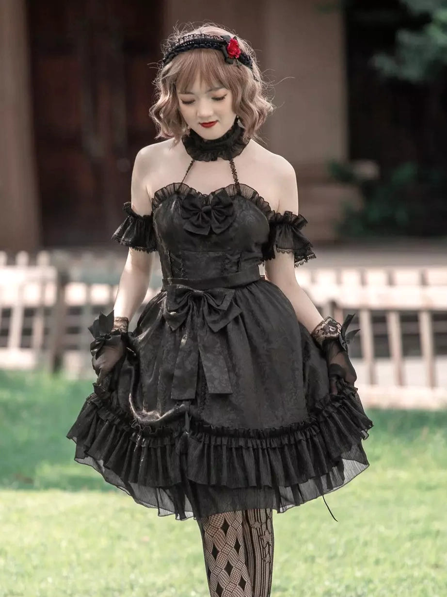 Gothic Lolita black dress with off-shoulder ruffled cuffs and layered ruffled skirt, front bow decoration detail, outdoor lawn setting