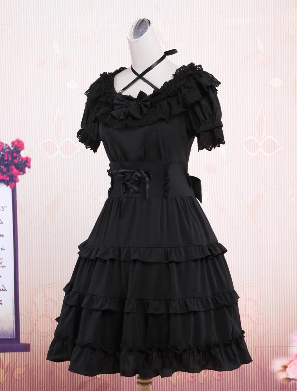 Black gothic lolita dress three-quarter angle view showing side bow sash tiered ruffle construction and authentic lolita silhouette