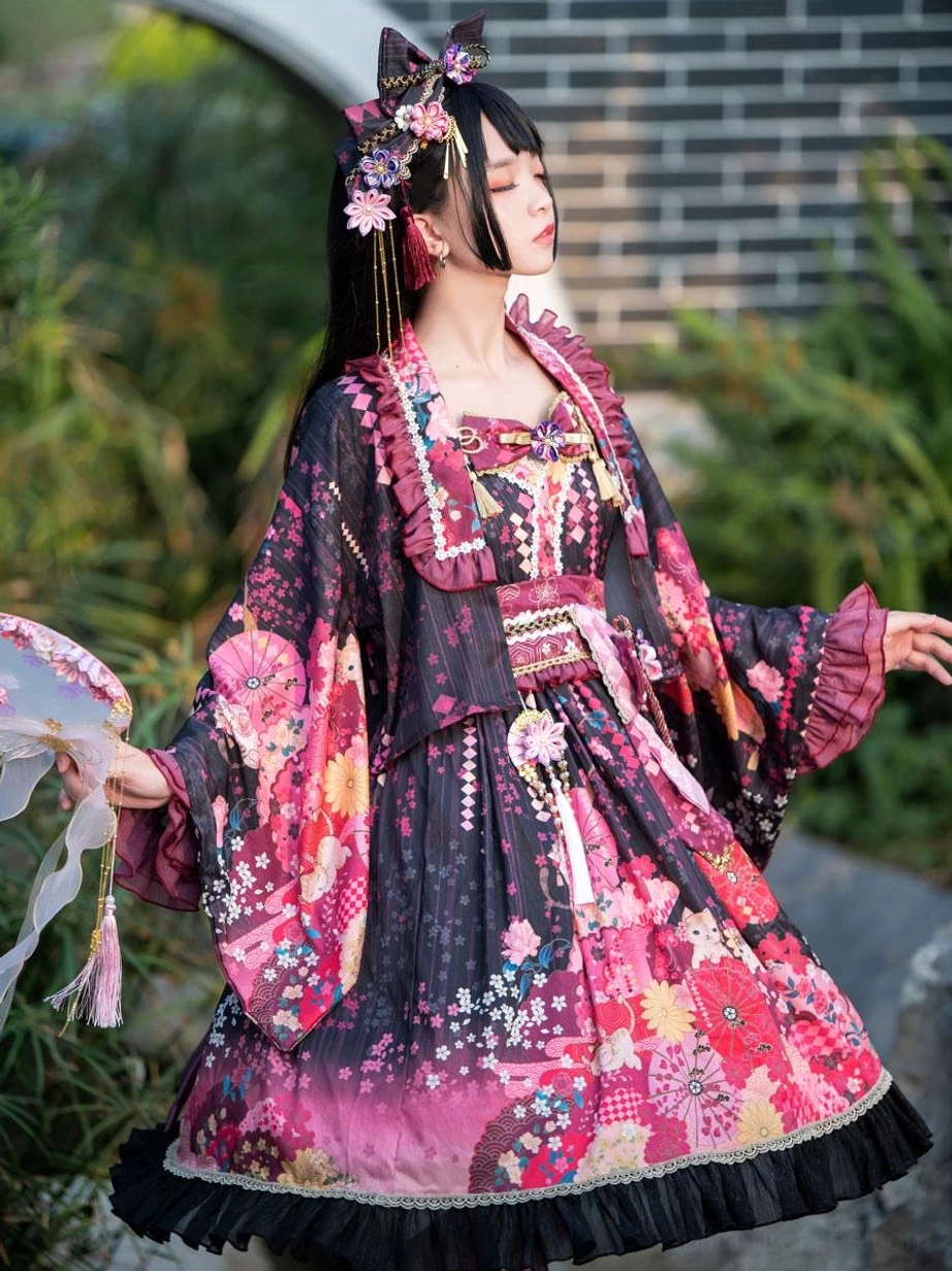 Three-quarter side view of black lolita kimono dress with floral print wide sleeves against brick wall and greenery