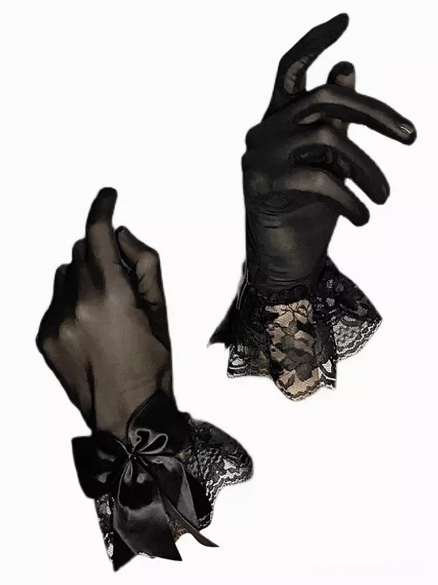 Flat lay of black sheer lolita gloves with floral lace wrist edge and satin bow decoration, showcasing delicate construction and gothic aesthetic detail