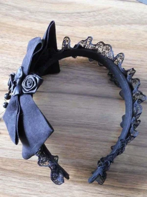 Black lolita headband headdress flat lay top down view ruffled lace edge satin bow fabric rose decoration wooden surface