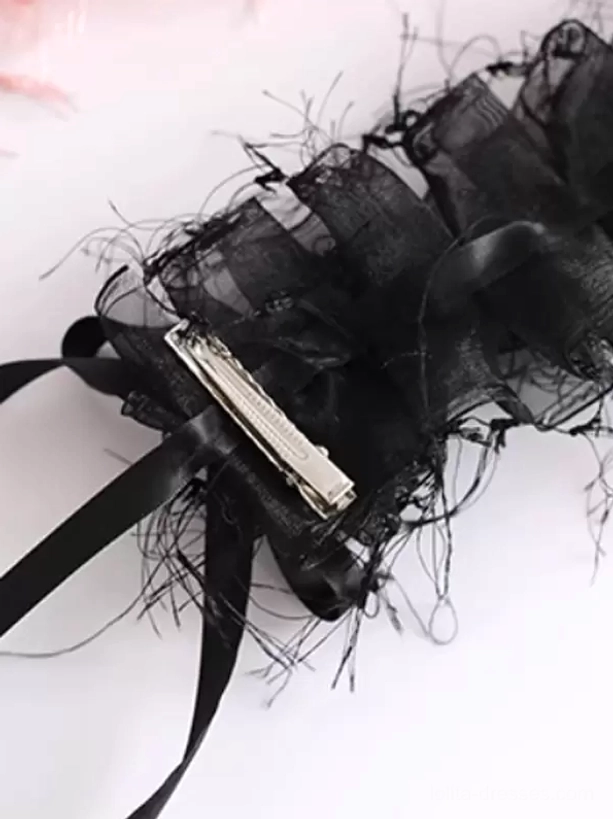 Black sweet lolita hair accessory with frayed organza ruffles, mini pink bows, metal hair clip attachment, and black ribbon straps shown in side flat view