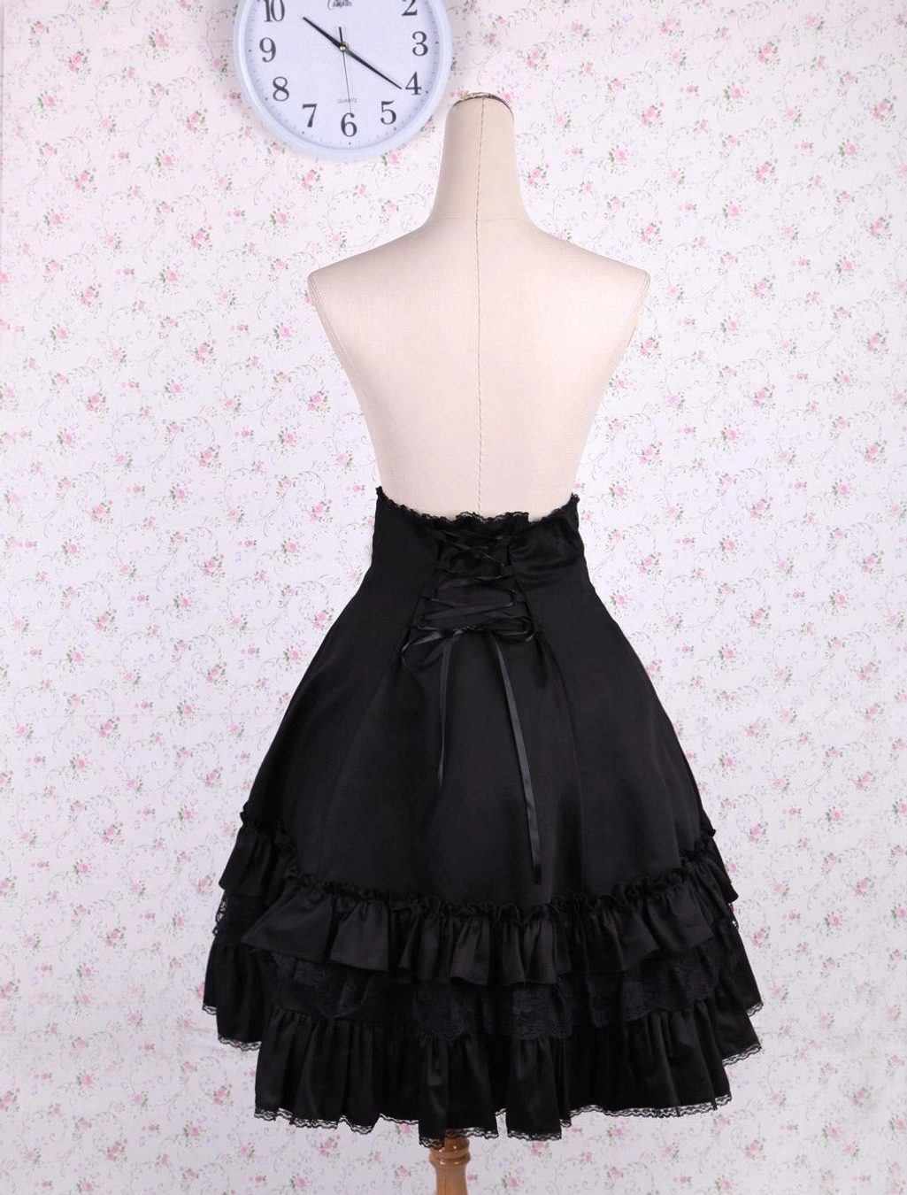 Black classic lolita high-waist skirt back view with lace-up closure and layered ruffled lace hem detail on mannequin