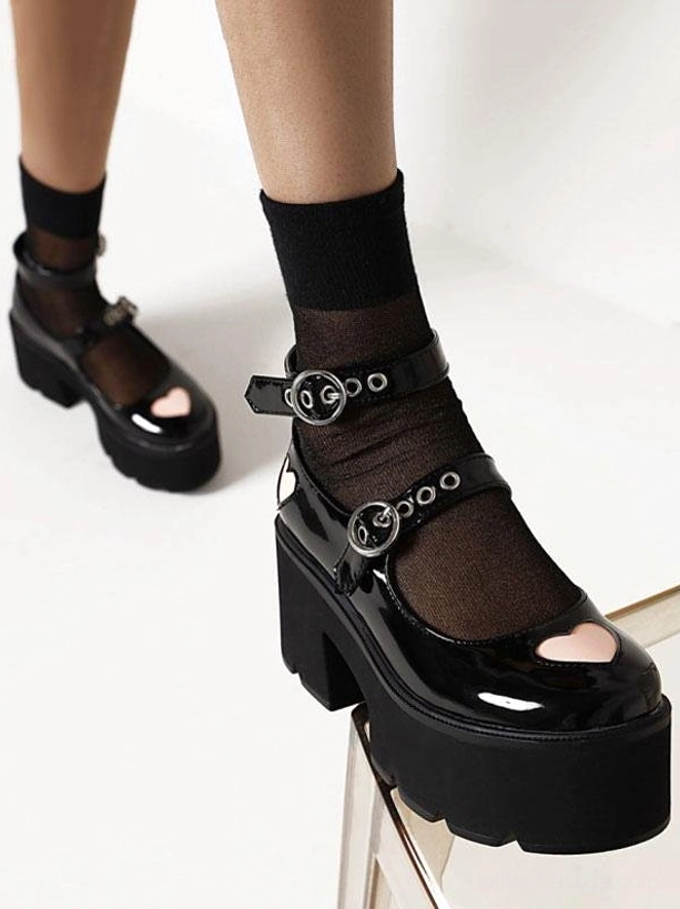 Black lolita platform shoes side three-quarter view showing chunky platform heel and heart cutout toe design with patent leather finish