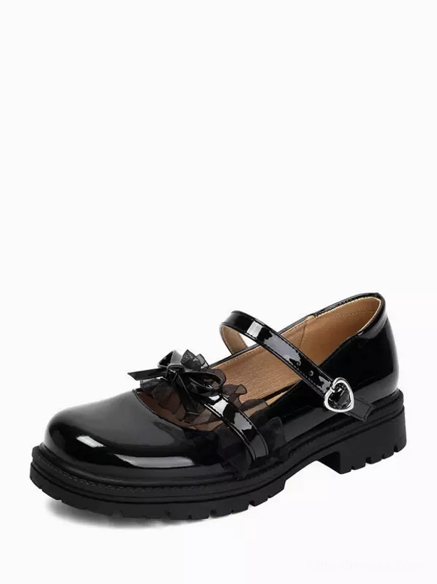 Single black lolita mary jane shoe static frontal side view on brown background with glossy pu leather, lace bow and heart-shaped ankle buckle