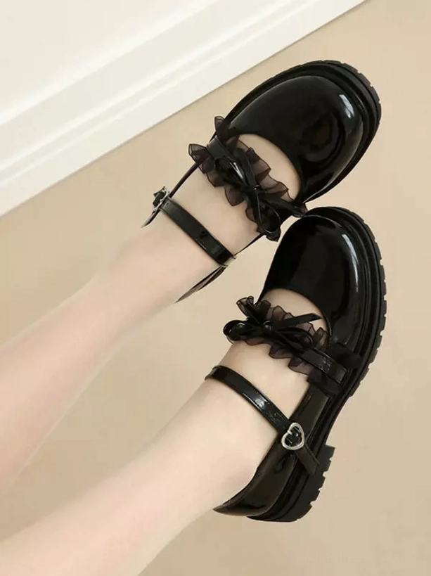 Black lolita mary jane shoes overhead double feet view showing glossy pu leather, ruffle bow trim, heart buckle and thick black outsole
