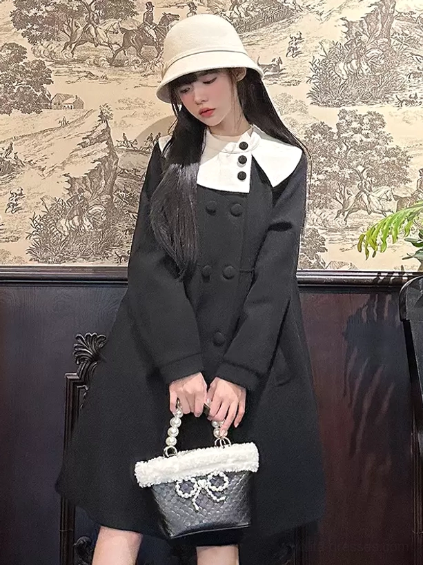 Black lolita overcoat with contrast Peter Pan collar standing front view, bow-decorated handbag accessory, vintage tapestry wall background
