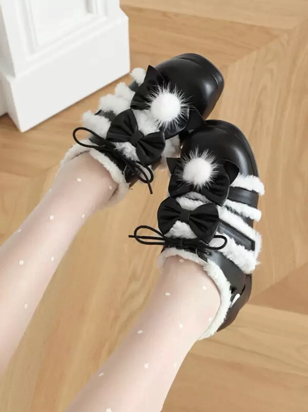 Black lolita platform bow pumps with pom-pom detail and white fuzzy trims, front low angle view with polka-dot sheer tights