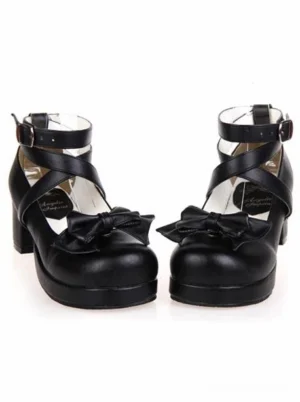 Black lolita platform heels three-quarter front angle displaying decorative front bow, cross buckle ankle straps, and round toe silhouette