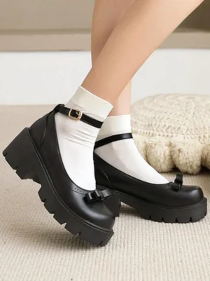 Black lolita platform shoes with lug sole and adjustable ankle strap buckle closure, low angle side view showcasing thick chunky heel construction and Mary Jane silhouette design