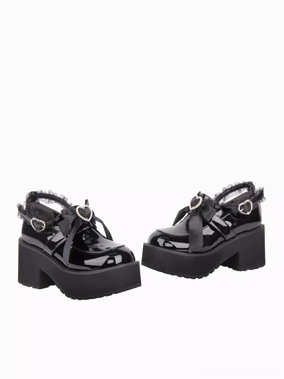 Top-down flat lay view of black lolita platform shoes showing chunky block heel structure, matching decorative hardware, and round toe silhouette design