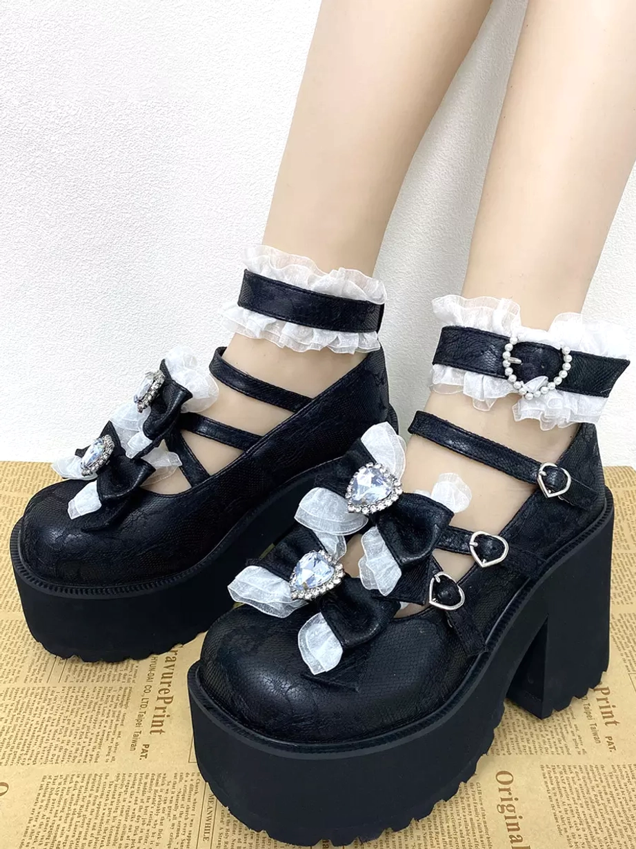 Worn black lolita platform pumps side view on model legs cross straps ruffled ankle cuffs heart rhinestone bow details vintage background
