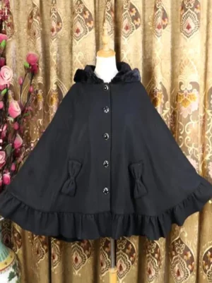 Black Lolita poncho coat close-up front view featuring plush collar, button details, and decorative bow pocket embellishments on vintage backdrop