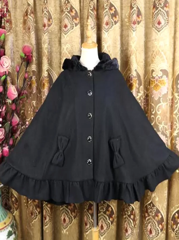 Black Lolita poncho coat close-up front view featuring plush collar, button details, and decorative bow pocket embellishments on vintage backdrop