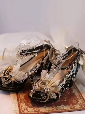 Black lolita shoes with champagne gold bow and pearl lace decorations displayed in flat three-quarter angle on patterned vintage rug