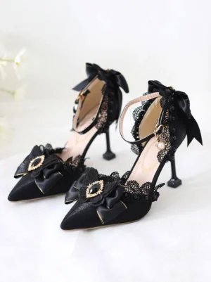 Black lolita pumps featuring pearl-adorned ankle strap, back heel bow detail, and pointed toe silhouette on plain white backdrop - front three-quarter angle showing decorative elements