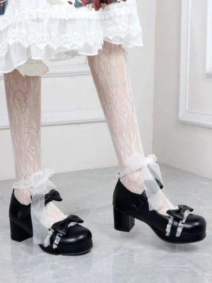 Black lolita heeled pumps showcasing smooth polyurethane leather finish with bow decorations, paired with ruffled lace socks, overhead side angle
