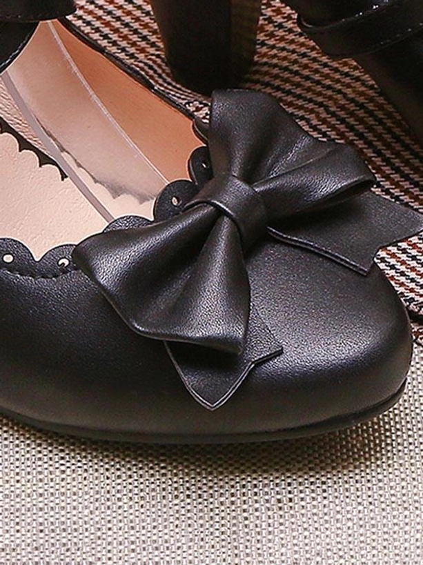Black lolita shoes close-up front view highlighting large decorative PU leather bow scalloped shoe opening and block prism heel