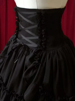 Close-up detail view of Black Gothic Lolita skirt waist featuring crisscross ribbon corset detailing, gathered ruffled trims and decorative bows, showcasing intricate construction and embellishment