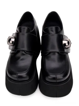 Black lolita platform pumps front flat lay view displaying round toe shape velcro strap closure with oversized skull buckle matte black pu leather on white background
