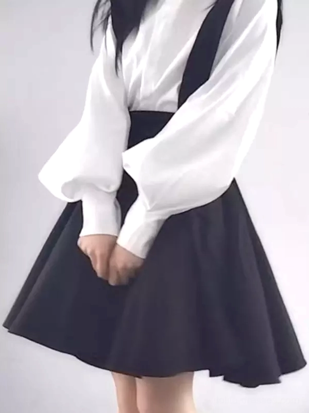 Black lolita suspender skirt side view with lantern sleeve blouse showing skirt structure and drape