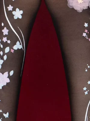 Close-up detailed view of Lolita printed black tights showing vine and pastel floral patterns with butterfly motifs on sheer black base
