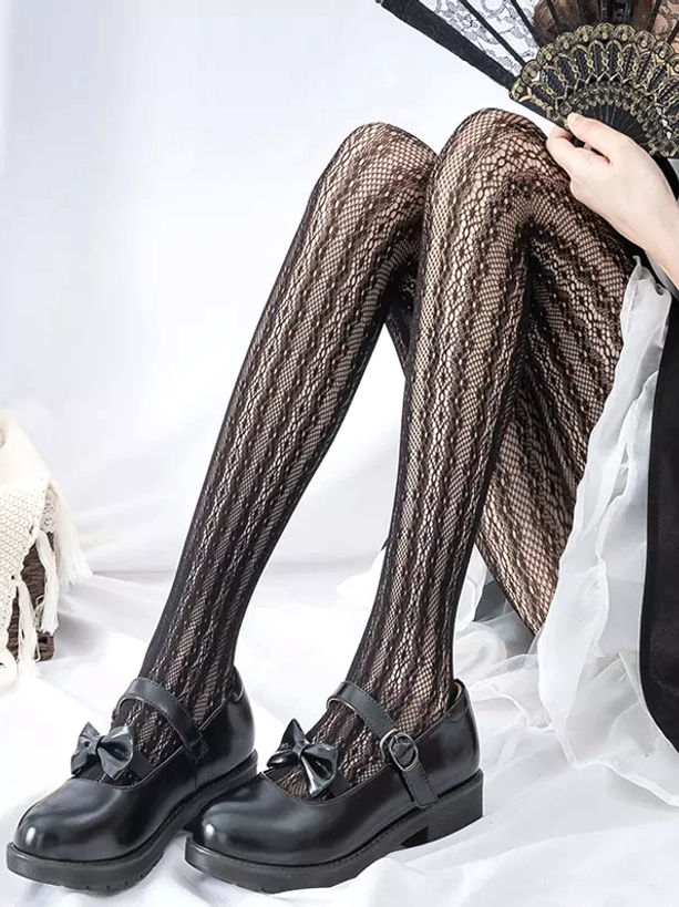 Black lolita mesh tights side seated view with folding fan accessory and maid costume detail