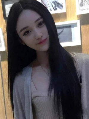 Long straight black lolita wig center-parted style three-quarter view on model indoors with framed wall background, showing sleek synthetic fiber hair and elegant straight silhouette perfect for classic lolita coordinate